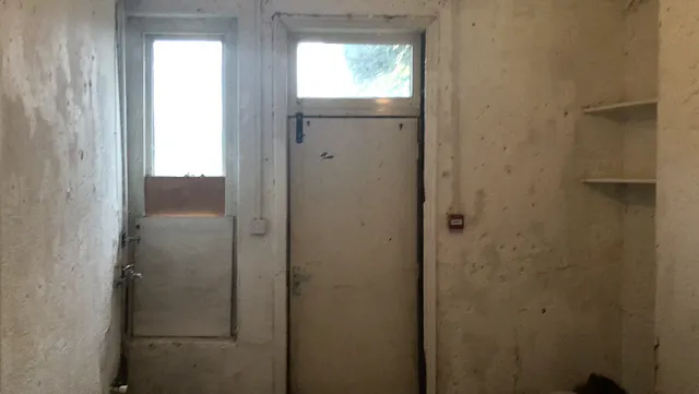 Basement doorway and shelving before restoration